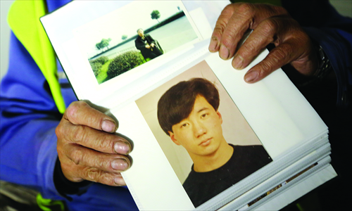 Shen shows pictures of his son, killed by street vendor Xia Junfeng. Photo: Yu Weihua 