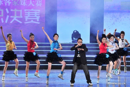 Girls perform with a performer in the final of the 5th World Hakka Girl Contest in Meizhou, south China's Guangdong Province, Jan. 6, 2013. (Xinhua/Zhong Xiaofeng)