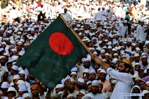 A Muslim holds Bangladeshi flag during a grand rally at Motijheel area in Dhaka, Bangladesh, April 6, 2013. Tens of thousands of Islamists under the banner of Hefazat-e-Islam from across Bangladesh poured into the key commercial hub of the capital city to join a grand rally, demanding action against the 