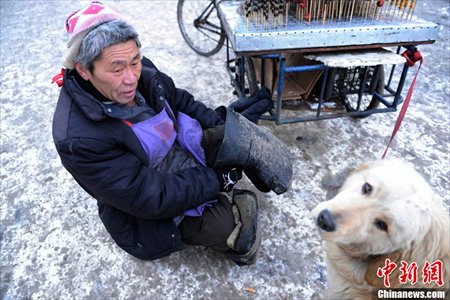 Big Yellow’s owner fixes the straps on his legs. Photo: Chinanews.com