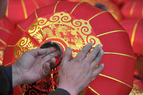 A villager makes a red lantern at a workshop in Yangzhao Village, a lantern production base in Jishan County of Yuncheng City, north China's Shanxi Province, Jan. 12, 2013. Chinese people traditionally hang red lanterns to greet and celebrate the Spring Festival, which falls on Feb. 10 this year. (Xinhua/Gao Xinsheng) 