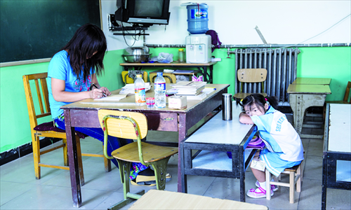 A teacher prepares for lessons while a student rests at her desk before class begins on September 3 in Shuren School for migrant children in Shijingshan district, Beijing. Photo: Li Hao/GT