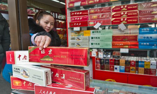 A shop owner points out a Beijing brand cigarette at a store in Dashilan, Xicheng district Tuesday. Production of this brand ceased in 2009. Photo: Li Hao/GT