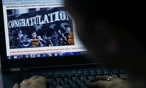 A Thai person looks at a website displaying a picture of a mural on campus depicting Adolf Hitler along with several comic book heroes inside, in Bangkok on July 16. Photo: CFP