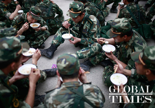 Police eat amid rescue efforts in Lingguan town, Baoxing county, Sichuan Province, on Sunday. Photo: Li Hao/GT