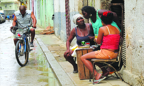 Women chat as a cyclist rides past in Havan. Photo: Lin Meilian/GT
