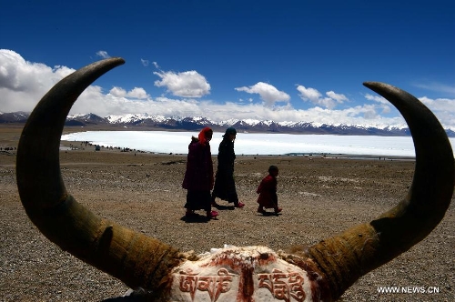 People walk along the icy lake Nam Co located at the boundary of Damxung and Baingoin counties, southwest China's Tibet Autonomous Region, on May 12, 2013. Lake Nam Co, the highest saltwater lake of the world at 4,718 meters above the sea level, is regarded as a sacred lake in Tibetan Buddhism. (Xinhua/Chen Tianhu)&nbsp; 