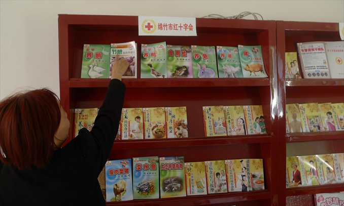 A staff member shows farming books at a Red Cross Boai Community center on May 7. Photo: Liu Dong/GT