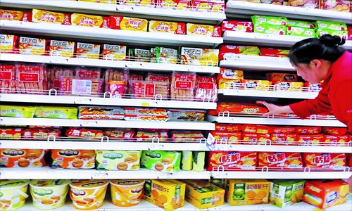 A customer shops at a supermarket in Shanghai. Despite China's economic slowdown, the country's food industry continues to grow, and the total output of the industry is expected to reach 10 trillion yuan ($1.599 trillion) this year, up from 7.8 trillion yuan in 2011, an industry official said Monday.  Photo: CFP