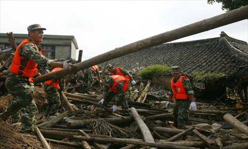 Rescuers work at the accident site after the dam of the Shenjiakeng Reservoir breached in Daishan County, east China's Zhejiang Province, Aug. 10, 2012. The death toll from a flood that occurred Friday morning following the breach of the Shenjiakeng Reservoir has risen to ten, local rescuers said. The flood also injured 27 people. Photo: Xinhua