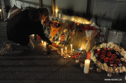 A woman lights candles in front of a memorial place at the Venezuelan Embassy to Chile after the news of Venezuelan President Hugo Chavez's death was released, in Santiago, capital of Chile, on March 5, 2013. Venezuelan President Hugo Chavez died on March 5. (Xinhua/Jorge Villegas)