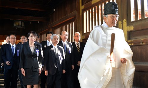 A Shinto priest leads a group of Japanese lawmakers to offer prayers for the country's war dead at the controversial Yasukuni Shrine in Tokyo on the occasion of the shrine's spring festival on Tuesday. The visit has aroused strong dissatisfaction from both China and South Korea. Photo: AFP