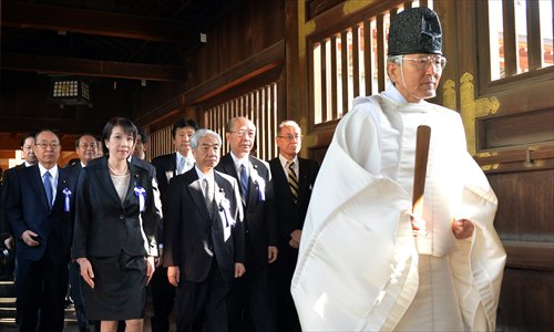 A Shinto priest leads a group of Japanese lawmakers to offer prayers for the country's war dead at the controversial Yasukuni Shrine in Tokyo on the occasion of the shrine's spring festival on Tuesday. The visit has aroused strong dissatisfaction from both China and South Korea. Photo: AFP
