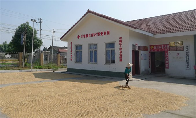 A villager dries crops in the yard of a Red Cross Boai Community center in Shidi, Sichuan Province on May 7. Photo: Liu Dong/GT