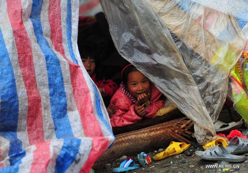Children rest in a tent at a temporary settlement for quake-affected people in Yuxi Village of Lushan County, southwest China's Sichuan Province, April 23, 2013. A 7.0-magnitude jolted Lushan County on April 20. (Xinhua/Xiao Yijiu) 
