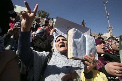  Palestinian women hold up the Koran, Islam's holy book, during a demonstration against the Israeli policeman who kick the Koran outside Damascus gate, in the old city of Jerusalem, on March 6, 2013. (Xinhua/Awad) 