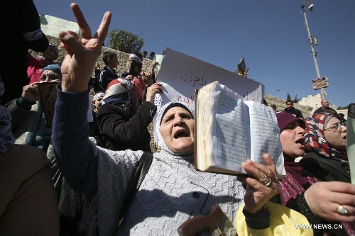 &nbsp;Palestinian women hold up the Koran, Islam's holy book, during a demonstration against the Israeli policeman who kick the Koran outside Damascus gate, in the old city of Jerusalem, on March 6, 2013. (Xinhua/Awad) 