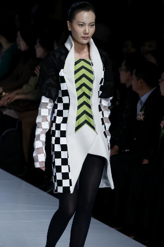 A model presents a creation designed by Zheng Caihong, a student of the College of Textiles & Fashion of Qingdao University, during a contest of New Designers Award in Beijing, capital of China, April 28, 2013. (Xinhua/Li Mingfang) 