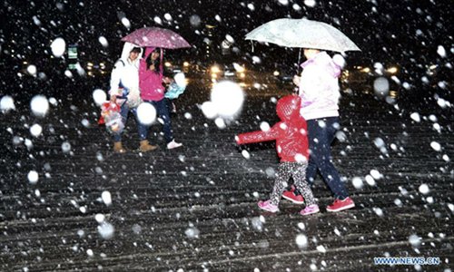 People walk against snow in Yanqing County of Beijing, capital of China, November 3, 2012. The cold wave that has swept northwestern China is moving eastward and is expected to bring blizzards to parts of northern China, the National Meteorological Center (NMC) forecast on Saturday. Heavy snow will hit Inner Mongolia, Hebei, Shanxi and the mountainous areas in western Beijing, according to a posting on the NMC website. The NMC has issued a blue warning on blizzards for Saturday, the lowest level in disaster alarm after yellow, orange and red. Photo: Xinhua