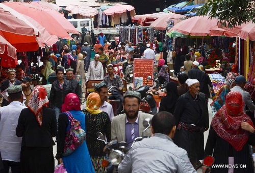 Crowds are seen at the Id Kah Bazaar in the city of Hotan, northwest China's Xinjiang Uygur Autonomous Region, July 1, 2013. (Xinhua/Zhao Ge)