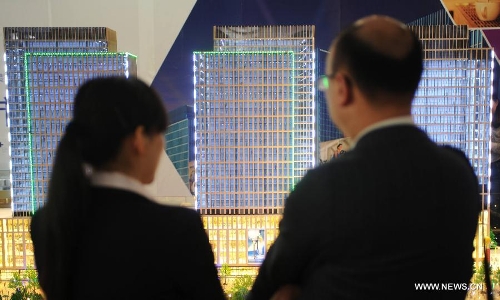 A visitor learns housing information from a salesperson at Shijiazhuang Spring Housing Fair in Shijiazhuang, capital of north China's Hebei Province, April 29, 2013. The fair, which kicked off on April 29, will last for four days. (Xinhua/Wang Xiao)