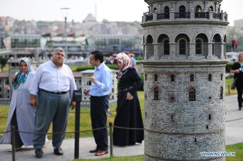 Visitors look at the miniature of Galata Tower in the Miniature park in Istanbul, Turkey, on May 11, 2013. The Miniaturk park is the first miniature park in Istanbul and has welcomed 6.5 million visitors over the past 10 years. (Xinhua/Lu Zhe) 