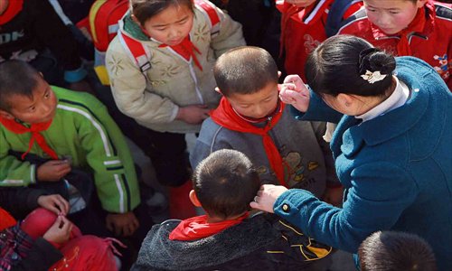 A teacher scolds one boy and holds another by his ear in a primary school playground in Northwest China’s Shaanxi Province. A recent spate of child abuse cases in schools has alarmed many parents. Photo: CFP