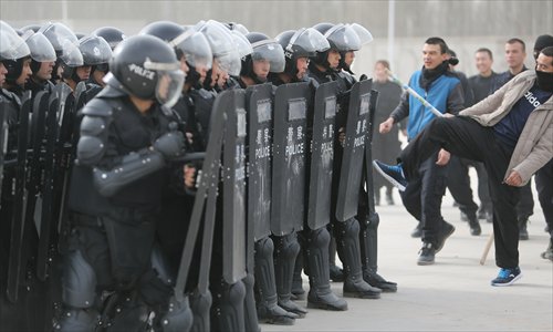 Police officers show how they protect themselves from attackers in Kashi,  Xinjiang Uyghur Autonomous Region on Saturday. More than  60 citizens visited a police camp to observe how police react and deal with terror attacks. Photo: CFP