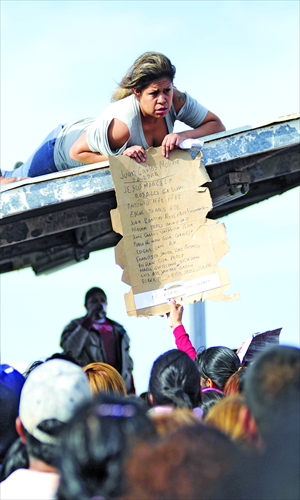 A woman shows a list of the inmates dead inside Apodaca prison as relatives wait outside on Sunday, near Monterrey, state of Nuevo Leon, Mexico. At least 38 inmates have been killed during a riot at a prison near the northern Mexican city, officials said. Photo: AFP 