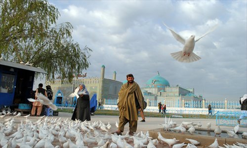 Afghan men and women feed pigeons in front of the shrine of Hazrat-i Ali ahead of Nowruz, the Persian New Year celebrations in Mazar-i Sharif on Sunday. Nowruz, one of the biggest festivals of the war-scarred nation, marks the first day of spring and the beginning of the year on the Persian calendar. Photo: AFP