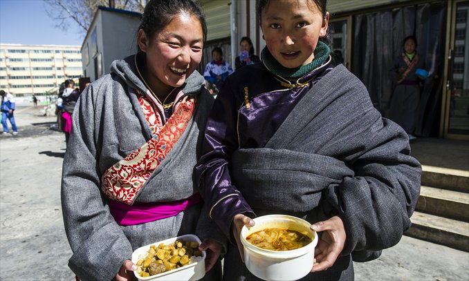 Tibetan students Gonpo Tso and Rinchen Tso show their lunch - rice with potato and beef, and beef soup with vermicelli, each dish costing 4 yuan. Photos: Li Hao/GT