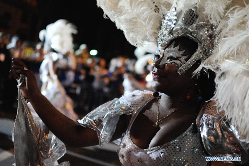 A dancer participates in the 2013 Carnival Inauguration Parade on the July 18 Avenue in Montevideo, capital of Uruguay, on Jan. 25, 2013. Various artists participate in the carnival, which attracts more than 100,000 people each year in the July 18 Avenue, according to the local press. (Xinhua/Nicolas Celaya) 