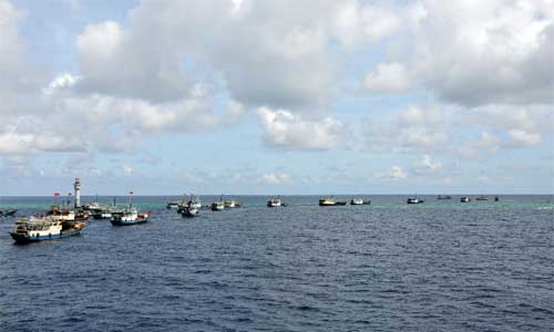 Fishing vessels sail into the lagoon of Zhubi Reef of south China Sea in turn on July 18, 2012. A fleet of fishing vessels from China's southernmost province of Hainan departed from Yongshu Reef on Tuesday night. The fleet arrived at Zhubi Reef at about 10 a.m. Wednesday. The fleet of 30 boats, the largest ever launched from the island province, planned to fish and detect fishery resources near Zhubi Reef. Photo: Xinhua