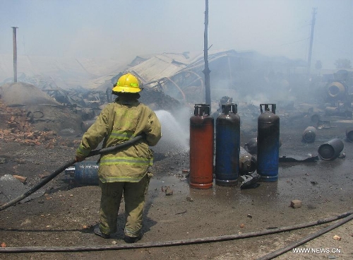 Afghan fire fighters try to extinguish fire in eastern Nangarhar province, Afghanistan, on June 7, 2013. More than thirty shops were burnt and three people were injured as a gas cylinder exploded at a market on Friday, an officials said. (Xinhua/Tahir Safi)