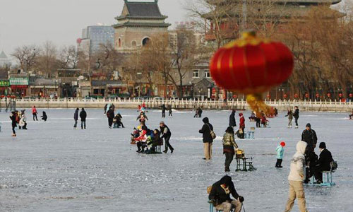 People enjoy themselves on the frozen Shichahai lake in Beijing, capital of China,December 22, 2012. Temperatures in Beijing could plunge to the lowest in almost three decades over the weekend, weather forecasters said Saturday. Photo: Xinhua