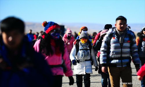 Hikers walk along Qinghai Lake, northwest China's Qinghai Province, January 1, 2013. 