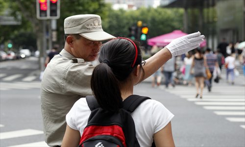 Traffic assistant Jin Mingbao gives directions to a passer-by. Photo: Cai Xianmin/GT