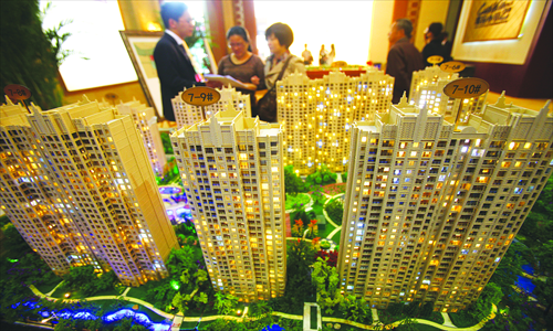 Potential home buyers look at a housing model in Ningbo, East China's Zhejiang Province.  
Photo: CFP