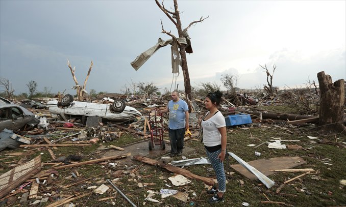 Philip Gotcher and his daughter Monica stand in the rubble of his house after a powerful tornado ripped through the area on Monday in Moore, Oklahoma. The tornado, reported to be at least EF4 strength and two miles wide, touched down in the Oklahoma city area on Monday killing at least 24 people. Photo: AFP