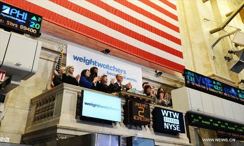 Traders and guests applaud after the first trading day of 2013 in the New York Stock Exchange, New York, the United States, on January 2, 2013. 