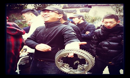 A cycling fan picks up a set of bicycle gears at the Bikes and Friends Café flea market. Photo: Courtesy of the café