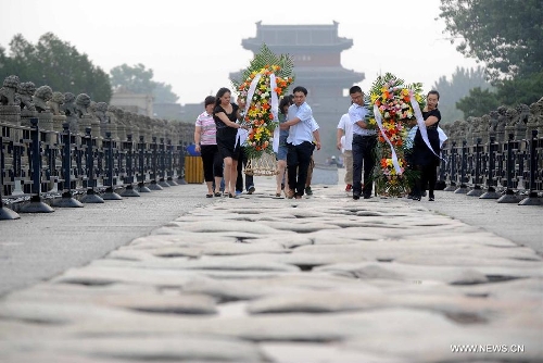  People present flower baskets on the Lugou Bridge during a memorial event marking the 76th anniversary of 