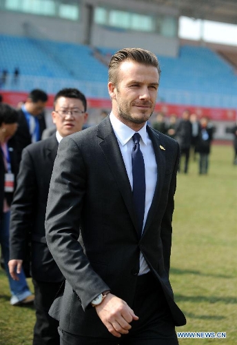 British soccer player David Beckham (front) arrives at the Qingdao Tiantai Stadium in Qingdao, east China's Shandong Province, March 22, 2013. Beckham visited Qingdao Jonoon Soccer Club as the ambassador for the youth football program in China and the Chinese Super League Friday. (Xinhua/Li Ziheng) 