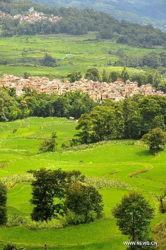 Photo taken on June 29, 2013 shows the village buildings and terraced fields in Yuanyang County of Honghe Prefecture in southwest China's Yunnan Province. The UNESCO's World Heritage Committee inscribed China's cultural landscape of Honghe Hani Rice Terraces onto the prestigious World Heritage List on June 22, bringing the total number of World Heritage Sites in China to 45. (Xinhua/Chen Haining) 
