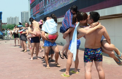 More than 20 couples participate in a romantic kissing competition held in Happy Magic Water Cube, a large-scaled water park in Beijing's Fengtai District, on July 6, 2013, the International Kissing Day. (Photo: china.org.cn / gmw.cn)