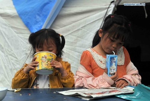 Girls eat breakfast at a temporary settlement for quake-affected people in Lushan Middle School in Lushan County, southwest China's Sichuan Province, April 26, 2013. A 7.0-magnitude jolted Lushan County on April 20. (Xinhua/Li Wen) 