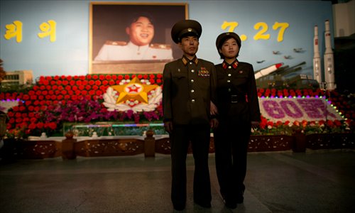 North Korean soldiers stand before a portrait of late North Korean leader Kim Il-sung as they visit a 'Kimilsungia' flower festival in Pyongyang on Thursday. North Korea is marking the 60th anniversary of the end of the Korean War, which ran from 1950 to 1953, with a series of performances, festivals, and cultural events culminating with a large military parade. Photo: AFP