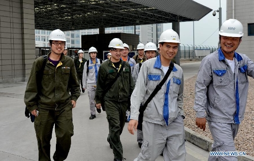 Employees walk in the Ningde Nuclear Power Plant in Ningde, southeast China's Fujian Province, on April 18, 2013. The nuclear power plant made its generator No. 1 begin operating on Thursday, making it the first of its kind in the province. Ningde nuclear power plant, with four generators in the first phase of construction, is co-funded and jointly run by Guangdong Nuclear Power Group, Datang International Power Generation Co. Ltd., and Fujian Energy Group Co. Ltd. (Xinhua/Zhang Guojun) 