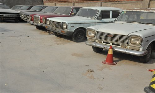 A collection of Xu Tao's classic cars stored in a Daxing district warehouse. 
Inset: Xu works on his 1958 Hongqi CA72. 
Photos: Zhang Yiqian/GT