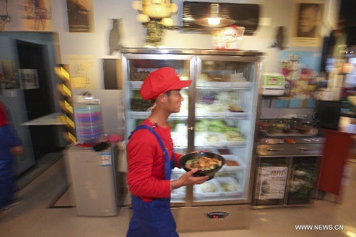 A waiter in the costume of Super Mario, a famous video game character, serves dishes at a Mario themed restaurant in Tianjin, north China, April 8, 2013. The restaurant that opened on Monday attracted many young customers due to its 